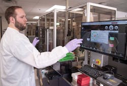 Cory Gunderson loading the WASP instrument in microbiology. Cory Gunderson loading the WASP instrument in microbiology.
