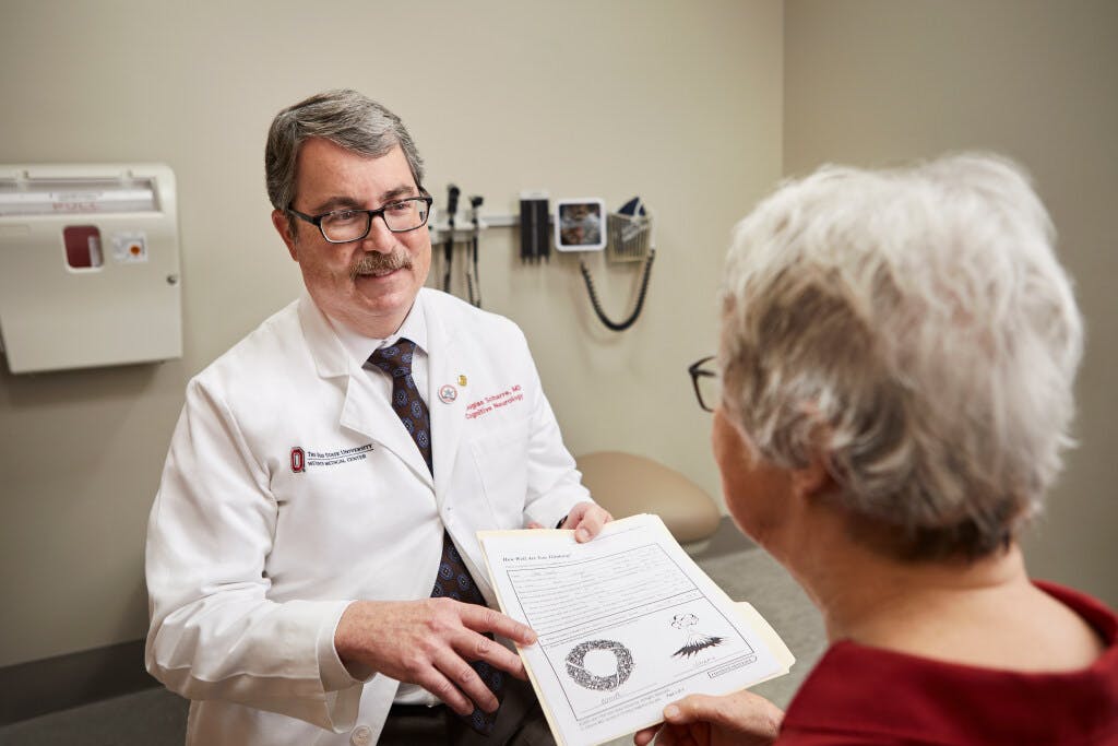 Douglas Scharre, MD, discusses the results of a cognitive test with a patient at The Ohio State University Wexner Medical Center. A new study finds using the self-administered test in primary care offices increased early diagnosis of cognitive disorders by six times, allowing treatment to start sooner.