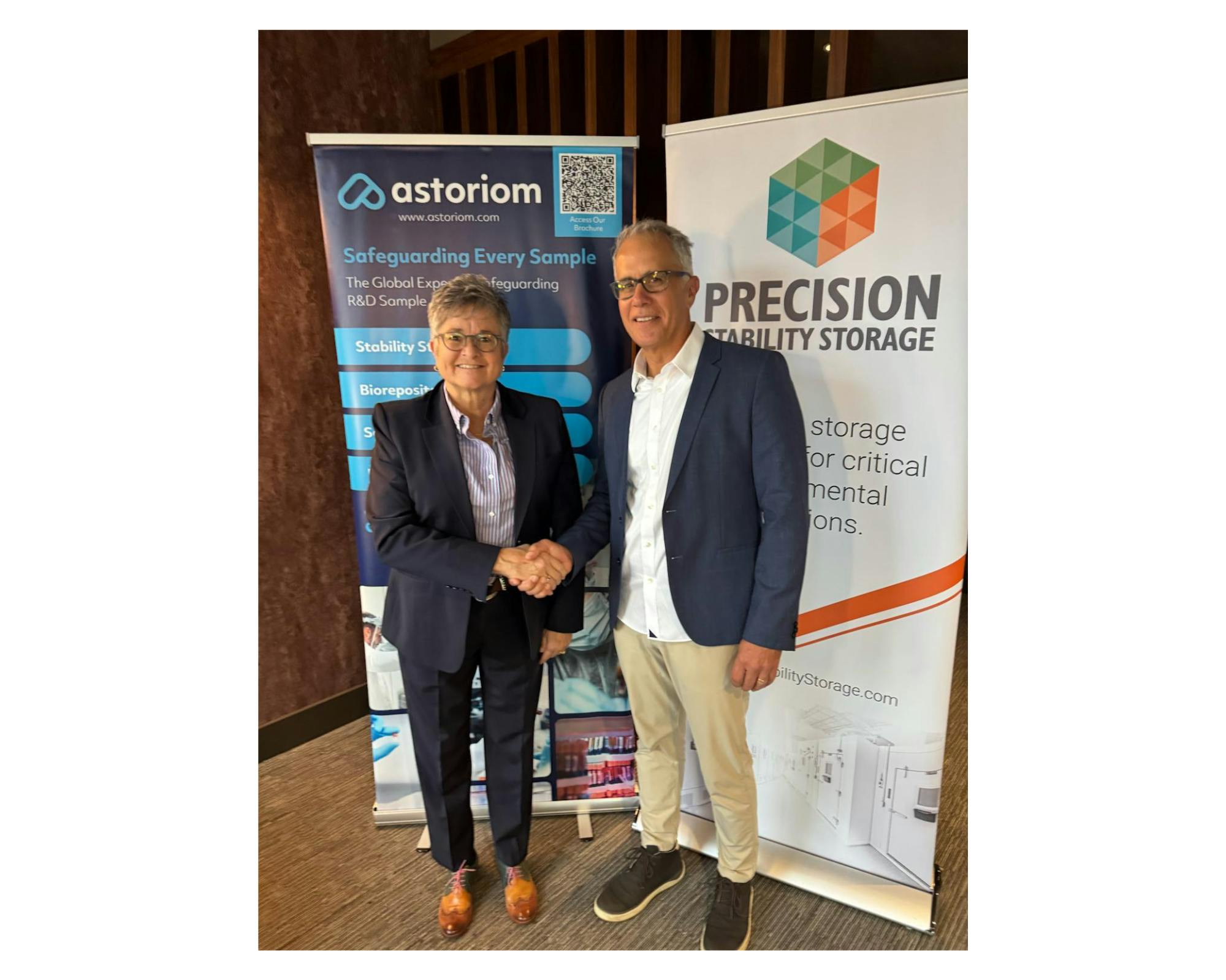 Lori A. Ball, Board Member, Astoriom and Clay Hile, Managing Director, Precision Stability Storage sign acquisition agreement.