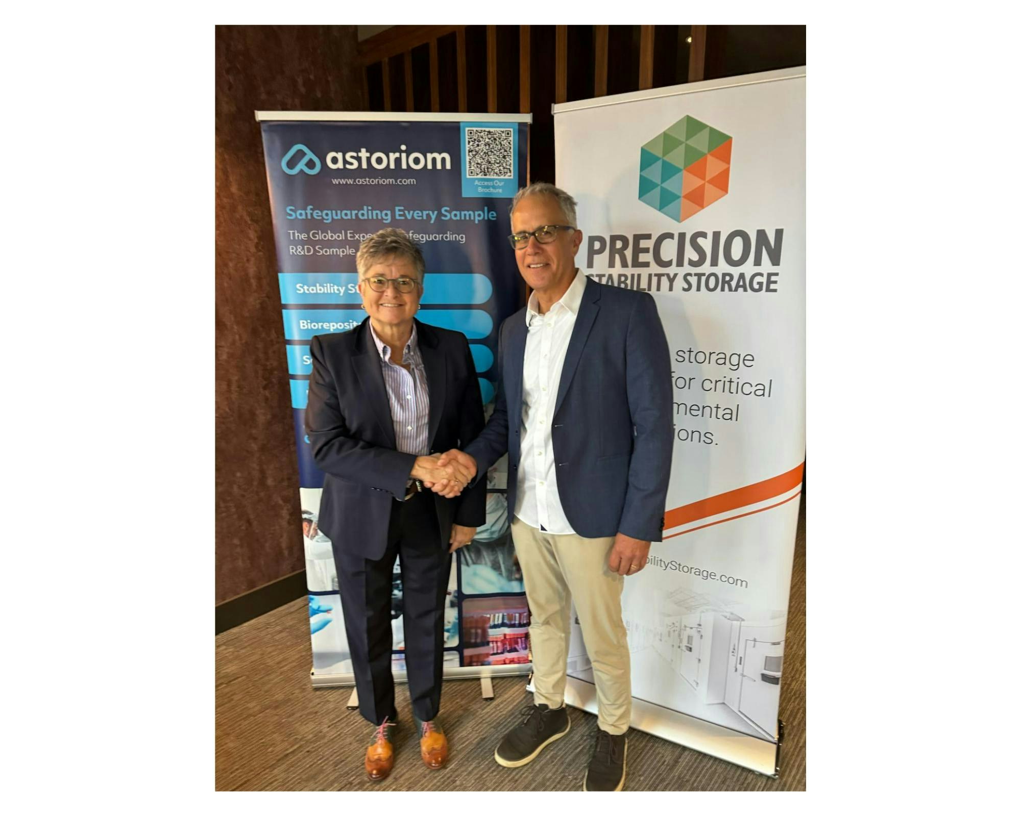 Lori A. Ball, Board Member, Astoriom and Clay Hile, Managing Director, Precision Stability Storage sign acquisition agreement.
